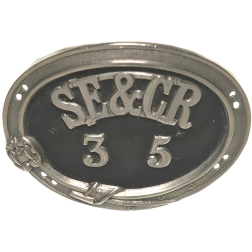 137 - A South Eastern and Chatham Railway cap badge, SE&CR 35, within belted garter, nickel with leather i... 