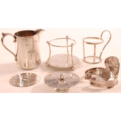 945 - Silverware, LNER milk jug, LMS and LNER trivets and similar, LMS bottle holder, LNER cup holder. (6)