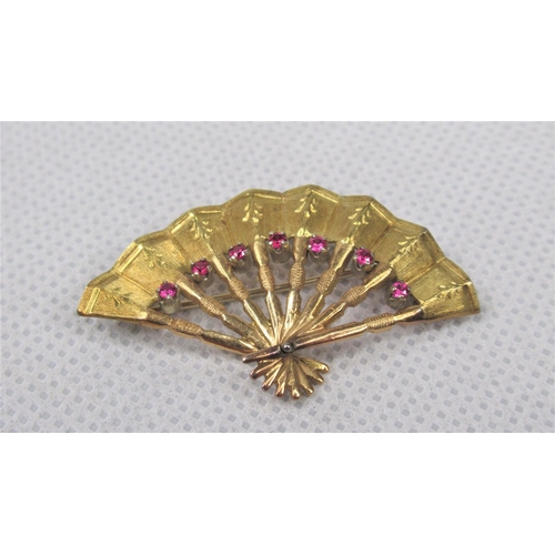 112 - An 18K Yellow Gold Brooch In The Shape of a Fan. Set with seven garnets. Approx 4.5cm. Weight approx... 