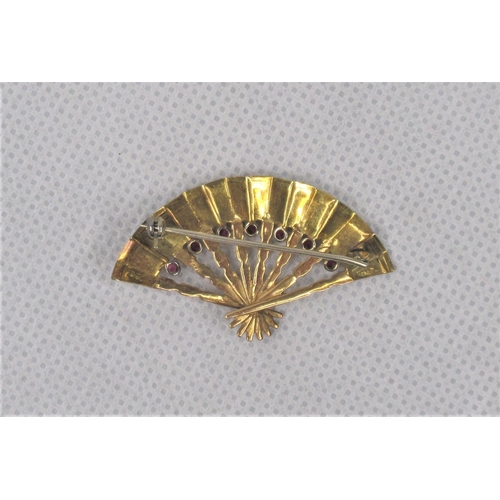 112 - An 18K Yellow Gold Brooch In The Shape of a Fan. Set with seven garnets. Approx 4.5cm. Weight approx... 