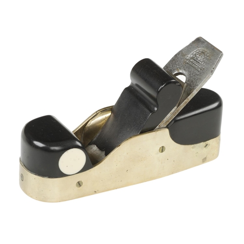 868 - A shapely brass smoother with ebony infill and scrolled wedge and 2 1/8