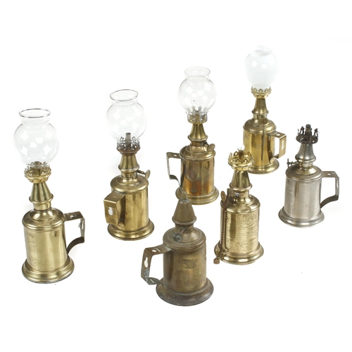 338 - A collection of 7 brass pigeon lamps, 4 with glass shades G+