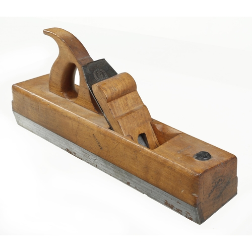 750 - An unusual handled beech badger plane by CLEGG set at an angle with iron sole and side and scrolled ... 