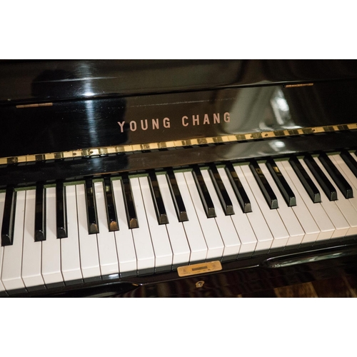 19 - Young Chang (c1987)  A Model U-121 upright piano in a bright ebonised case; together with a duet sto... 