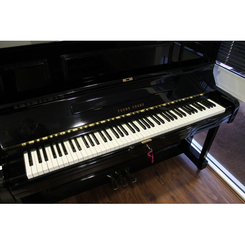 19 - Young Chang (c1987)  A Model U-121 upright piano in a bright ebonised case; together with a duet sto... 