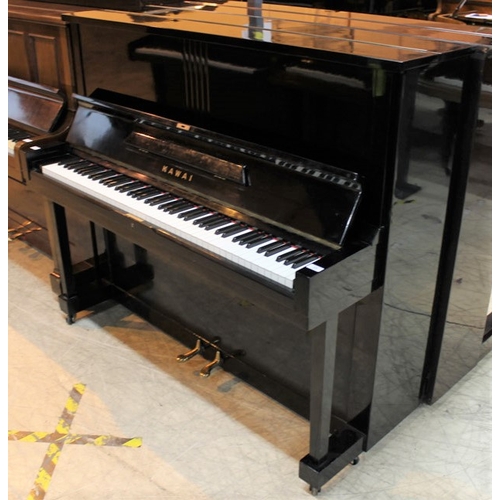 23 - Kawai (c1962)  An upright piano in a traditional style bright ebonised case