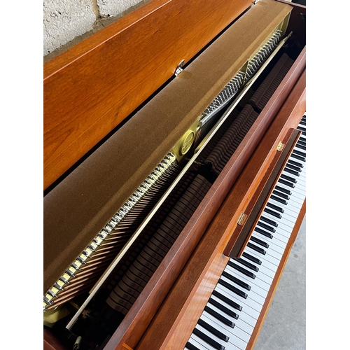 119 - Kemble (c1997)An upright piano in a traditional crossbanded yew and cherry wood case; together with ... 