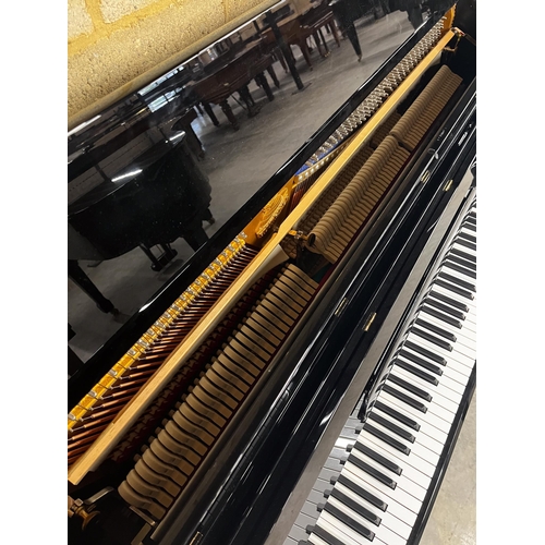 25 - Blüthner (c2015)A Model C upright piano in a traditional bright ebonised case; together with an adju... 