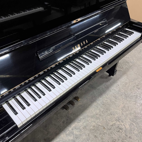 61 - Yamaha (c1973)A Model U2 upright piano in a bright ebonised case; together with a matching stool.... 