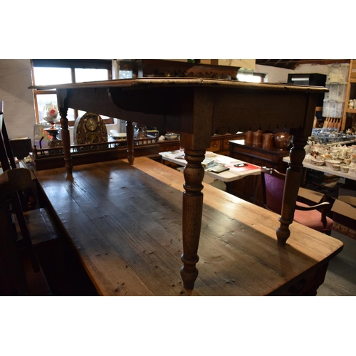 349 - Late Victorian oak kitchen table with boarded top with lobed apron piece turned legs with folding si... 