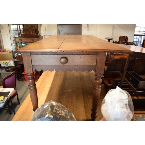 349 - Late Victorian oak kitchen table with boarded top with lobed apron piece turned legs with folding si... 