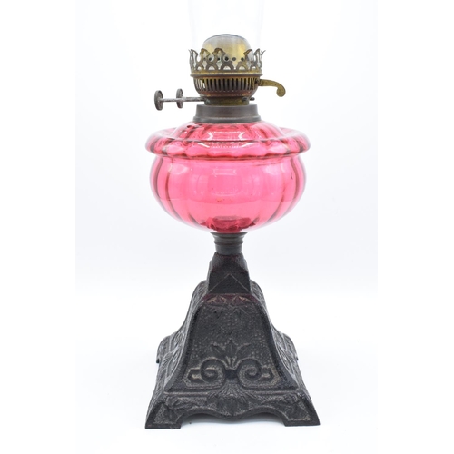 273 - Victorian cranberry oil lamp with a later chimney. Untested condition. Some damage to metalwork. See... 