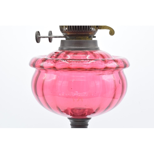 273 - Victorian cranberry oil lamp with a later chimney. Untested condition. Some damage to metalwork. See... 