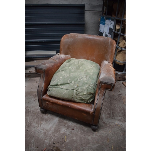 299 - Early 20th century French tan leather armchairs. Both in a poor state of condition with both in need... 