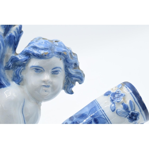 47 - English 19th century Delft model of a cherub holding a cornucopia in a tin glaze. Some chipping to t... 