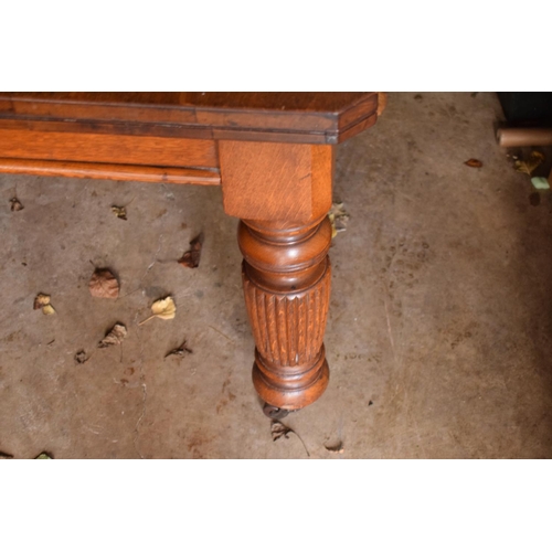 325 - Early 20th century golden oak dining table with a spare leaf and handle. In good condition with age ... 