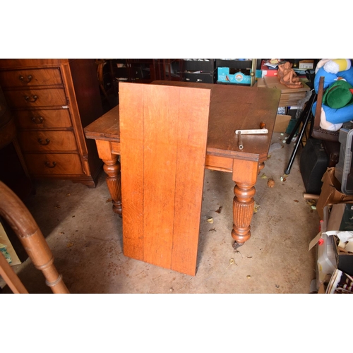 325 - Early 20th century golden oak dining table with a spare leaf and handle. In good condition with age ... 