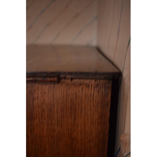 317 - Edwardian oak chest of drawers on caster wheels. There some splits to the wood and sections of missi... 