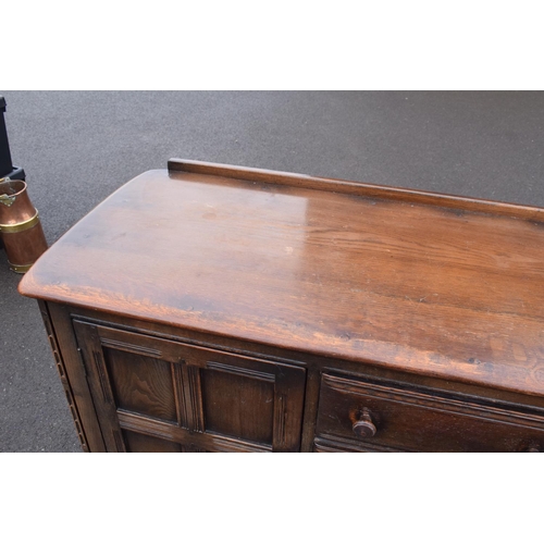 322 - Ercol dark elm sideboard with 2 doors and 4 drawers. In good functional condition with some areas of... 