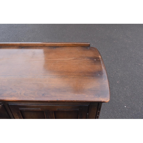 322 - Ercol dark elm sideboard with 2 doors and 4 drawers. In good functional condition with some areas of... 