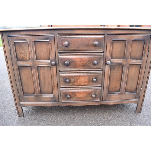 322 - Ercol dark elm sideboard with 2 doors and 4 drawers. In good functional condition with some areas of... 