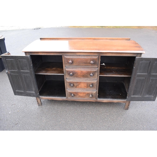 322 - Ercol dark elm sideboard with 2 doors and 4 drawers. In good functional condition with some areas of... 