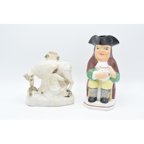 198 - 19th century Toby jug together with a cow spill vase (2). The spill vase has been damaged with chips... 