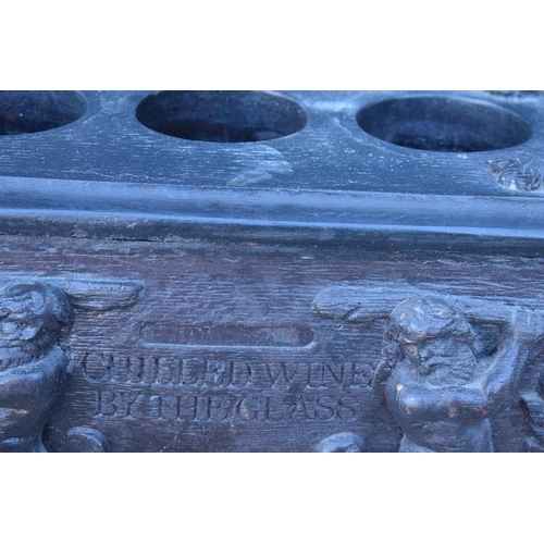 307 - Heavy duty wooden 20th century wine bottle holder with carved decoration of grapes and men. Generall... 