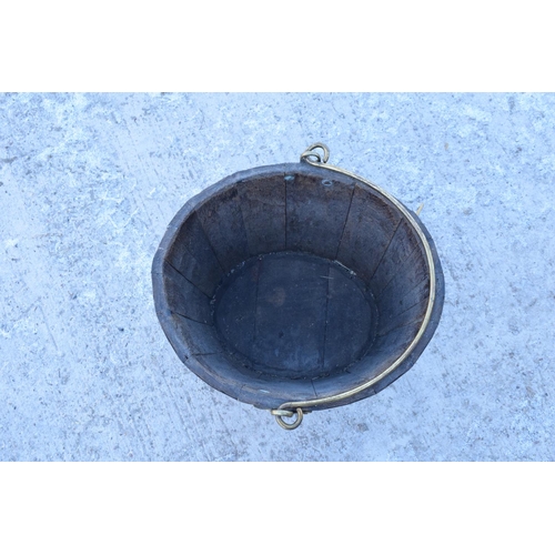 317 - Antique wooden and brass coopered oval bucket with brass handle. Some oxidation on the brass. Genera... 