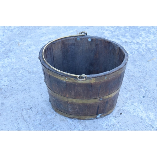 317 - Antique wooden and brass coopered oval bucket with brass handle. Some oxidation on the brass. Genera... 