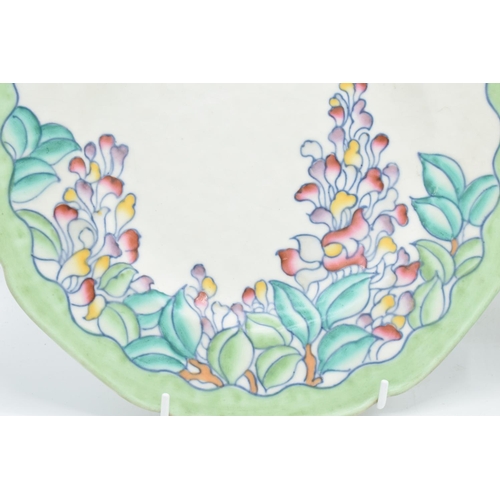 62 - Crown Ducal tubelined plates by Charlotte Rhead with floral scenes (2) Both are crazed heavily and a... 