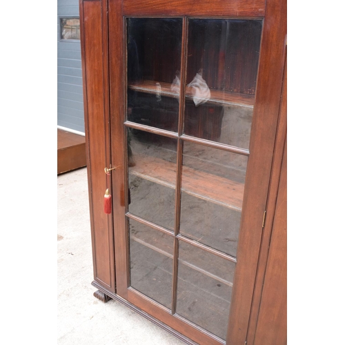 306 - Large Victorian mahogany bookcase on carved feet with foldout sides and a glass panelled door. 3 adj... 