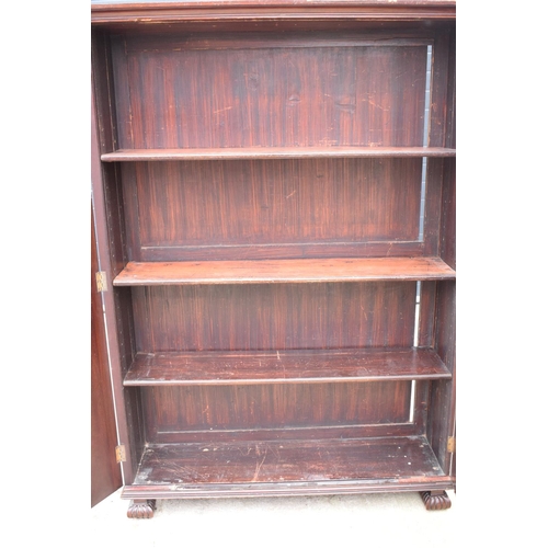 306 - Large Victorian mahogany bookcase on carved feet with foldout sides and a glass panelled door. 3 adj... 