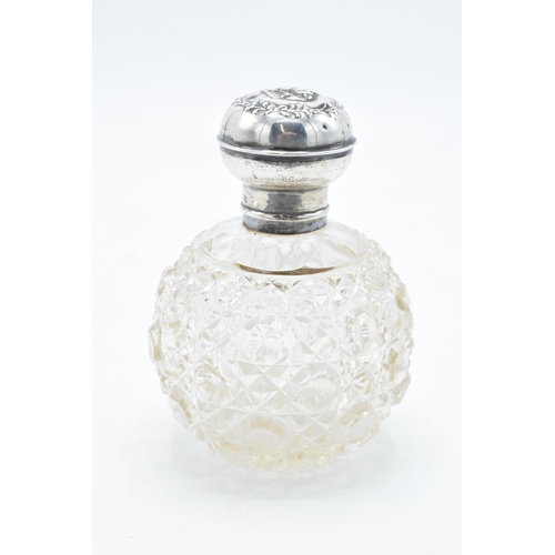 223 - A silver and glass scent bottle with Reynold's Angel on the silver top. With an associated stopper. ... 