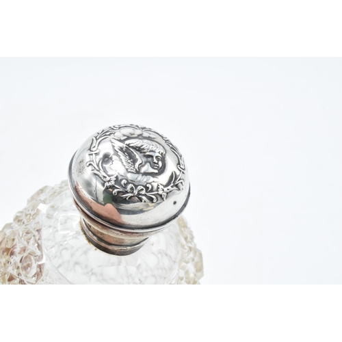 223 - A silver and glass scent bottle with Reynold's Angel on the silver top. With an associated stopper. ... 