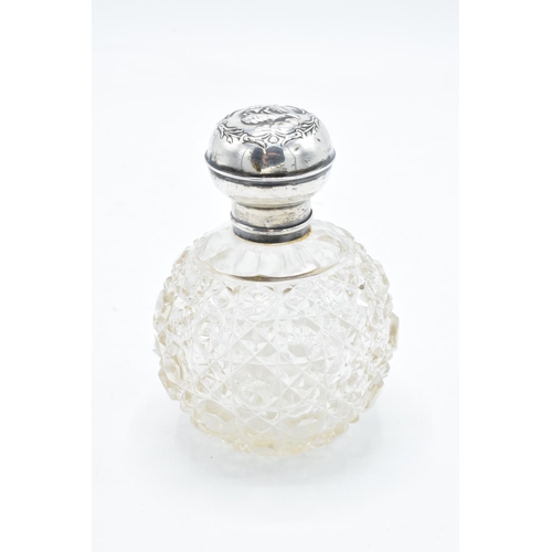 223 - A silver and glass scent bottle with Reynold's Angel on the silver top. With an associated stopper. ... 