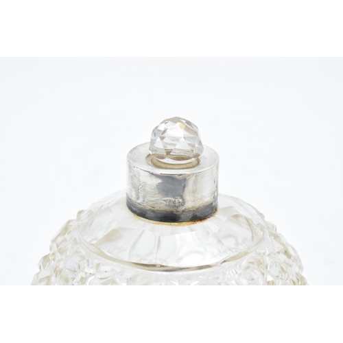 223 - A silver and glass scent bottle with Reynold's Angel on the silver top. With an associated stopper. ... 