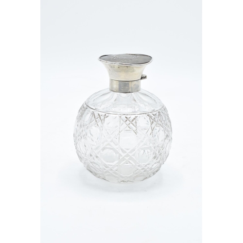 224 - A silver and glass scent bottle with a tortoiseshell style top. Hallmarks are rubbed. Crack to the t... 