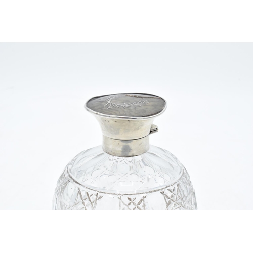 224 - A silver and glass scent bottle with a tortoiseshell style top. Hallmarks are rubbed. Crack to the t... 