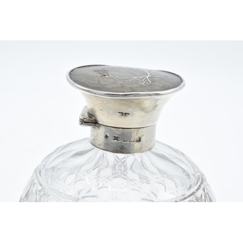 224 - A silver and glass scent bottle with a tortoiseshell style top. Hallmarks are rubbed. Crack to the t... 