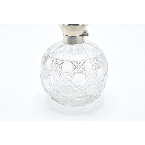 224 - A silver and glass scent bottle with a tortoiseshell style top. Hallmarks are rubbed. Crack to the t... 