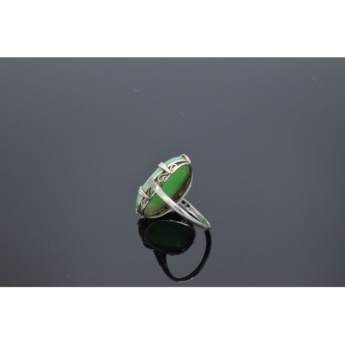 228 - Ladies platinum set jade & diamond ring: Jade or similar hardstone cabochon gemstone with diamond ch... 