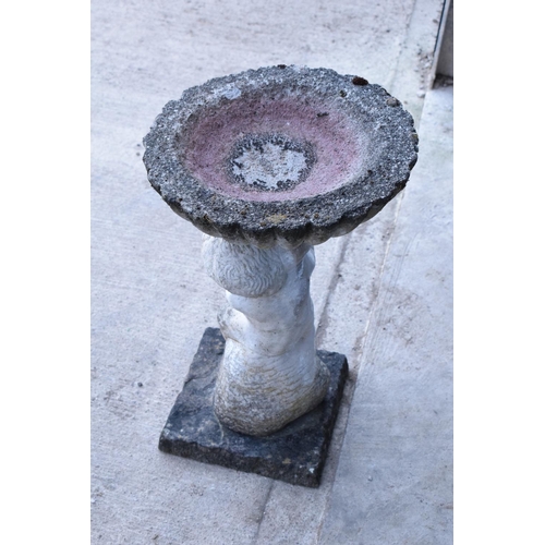 283 - A vintage garden statue in the form of a cherub bird bath on a base, 64cm tall made from reconstitut... 