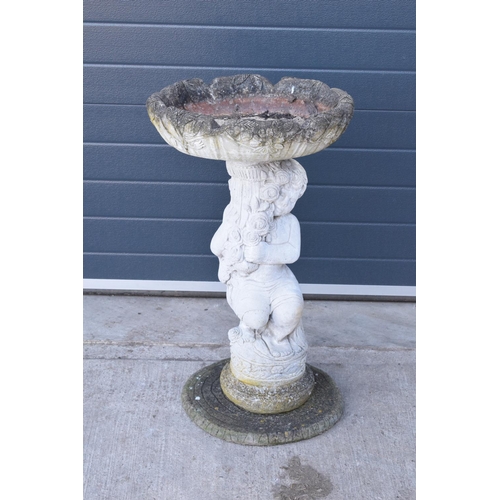 285 - A vintage garden statue in the form of a cherub bird bath on a tree ring base, 85cm tall made from r... 