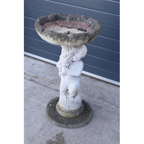 285 - A vintage garden statue in the form of a cherub bird bath on a tree ring base, 85cm tall made from r... 