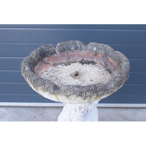 285 - A vintage garden statue in the form of a cherub bird bath on a tree ring base, 85cm tall made from r... 