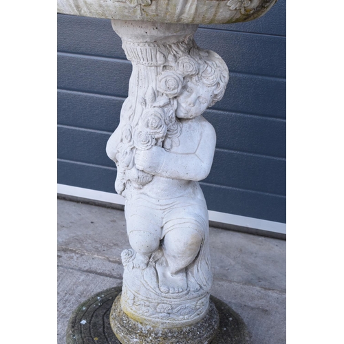 285 - A vintage garden statue in the form of a cherub bird bath on a tree ring base, 85cm tall made from r... 