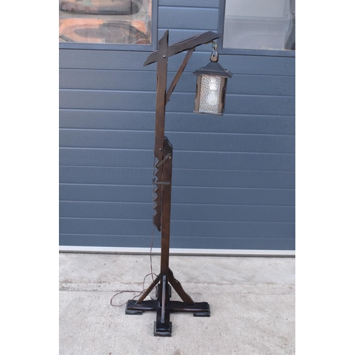 295 - A 20th century/ modern freestanding wooden lamp base in the style of an 18th century tavern/ street ... 