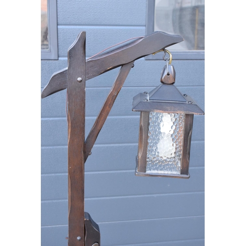 295 - A 20th century/ modern freestanding wooden lamp base in the style of an 18th century tavern/ street ... 