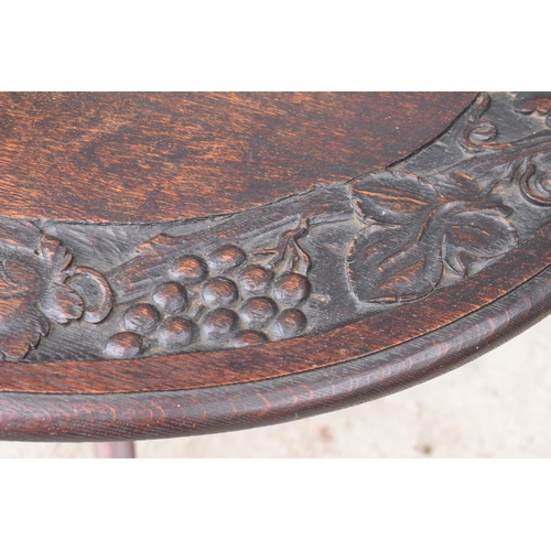 304 - Georgian thick oak oval tilt top table with later Victorian carving depicting fruit scenes. 84 x 72 ... 